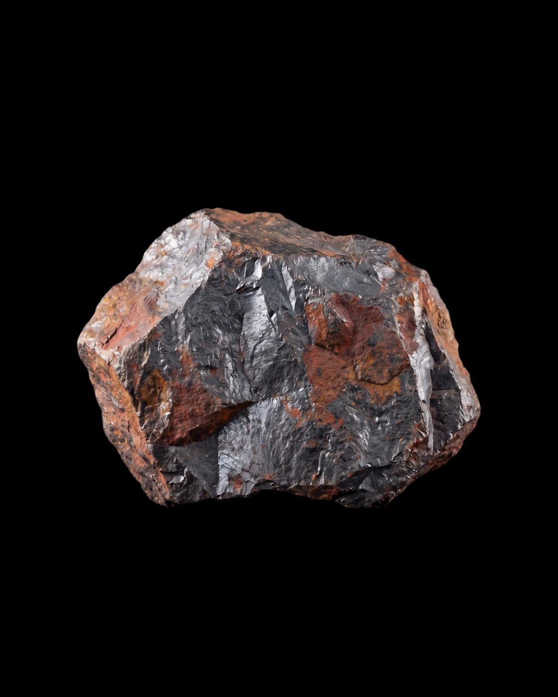 A lump of hematite iron ore, steel grey and rust red