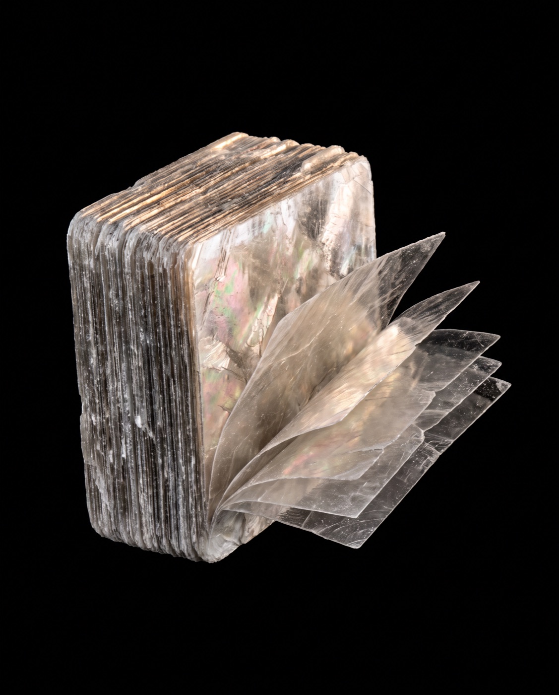 Natural muscovite mica: a book of silvery sheets, a few split thin